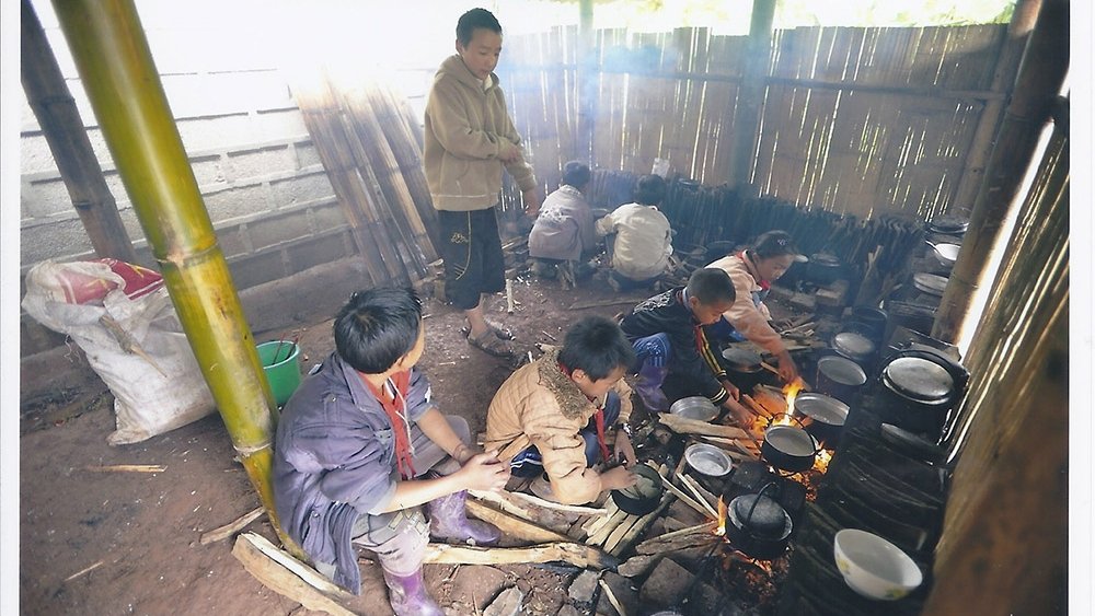 小朋友要自己煮飯，蹲在地上用磚砌成爐具。（圖：由受訪者提供）