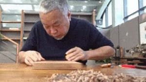 甘肅手工書藝人徐晉林在其工作室製作雕版敦煌壁畫的印刷品（圖：中新視頻）。