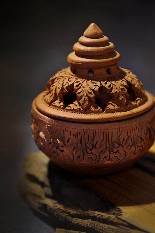 吉祥花紋手製香爐，產地為泰國北部村落。以紅土裝造，手工雕刻，頂部呈佛塔型，以顯當地佛教崇高之地位。