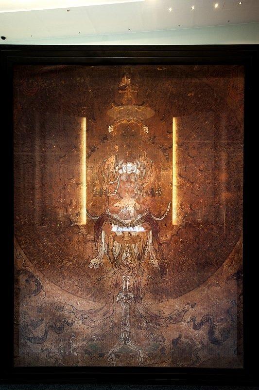會場展示了敦煌莫高第三窟千手千眼觀世音菩薩壁畫的複製圖像，它正是楊惠姍《千手千眼千悲智》琉璃雕像的藍本。