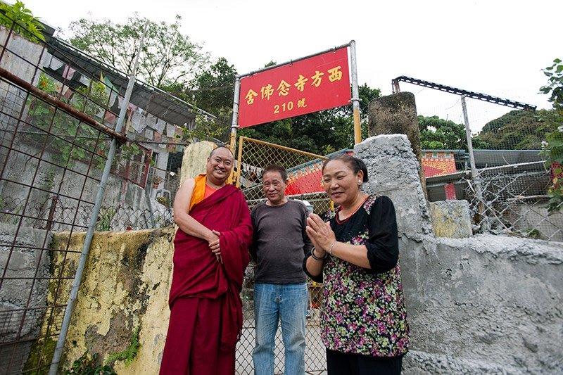 卓姬喇(右)及其丈夫於村屋前合照,左為哲蚌寺格西昂旺他親(Geshe Ngawang Tharchen)