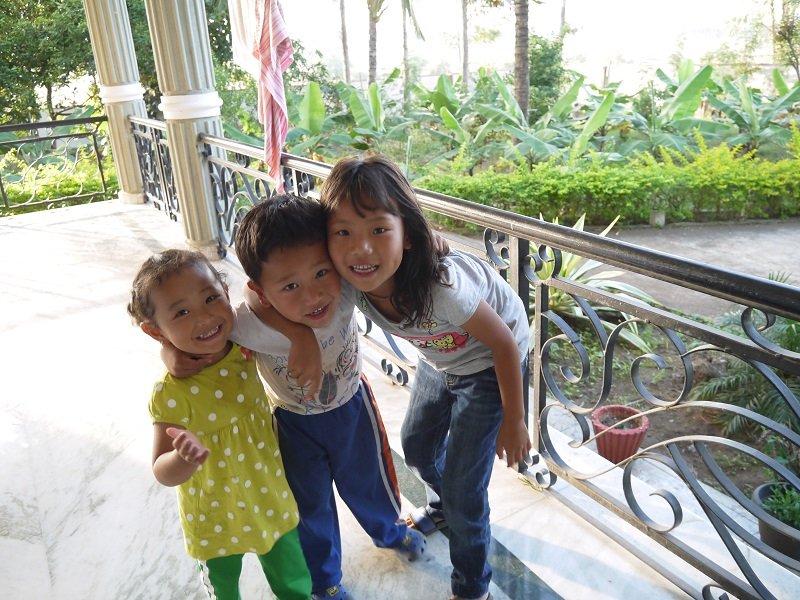 民宿老闆的一對可愛小寶寶(左一、二)在花園裏與鄰家女孩玩耍。後方可見自家種植的蕉樹和椰子樹。