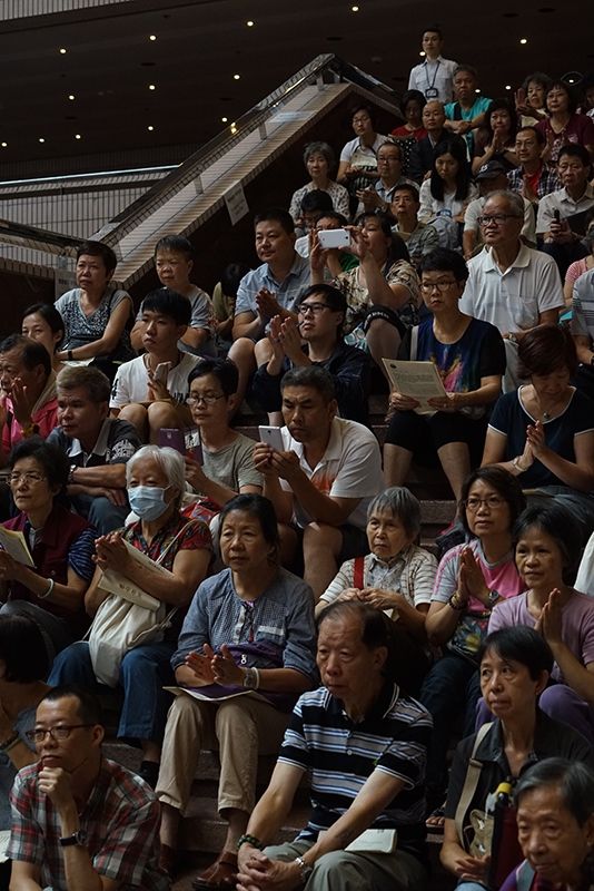 香港文化中心大堂的兩條樓梯坐滿了觀眾，但大家都不發一言，靜靜地欣賞五會念佛的唱誦。