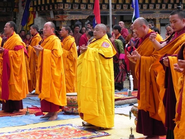 蓮花園仁波切（中）與不丹貝斯林寺僧眾進行法會，他們所穿的是七條布幅的黃色上衣