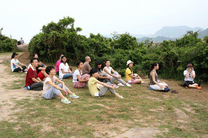 學員在山腰席地而坐,細心聆聽法師的開示。