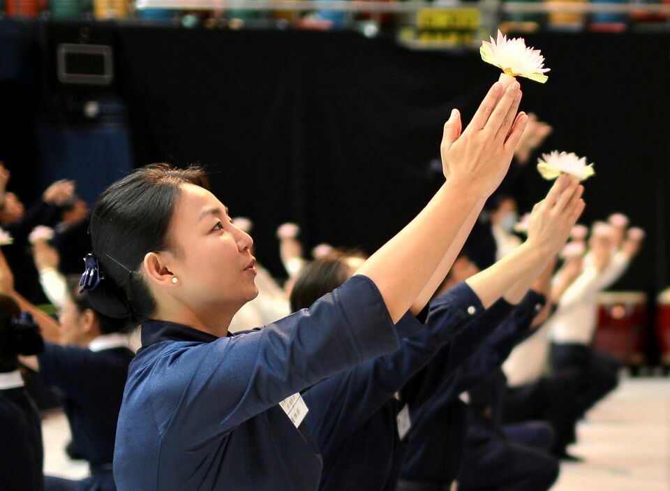 雅彬師姐和慈濟人一起手持蓮花，象徵回到心靈的故鄉「花蓮」。(被訪者提供)