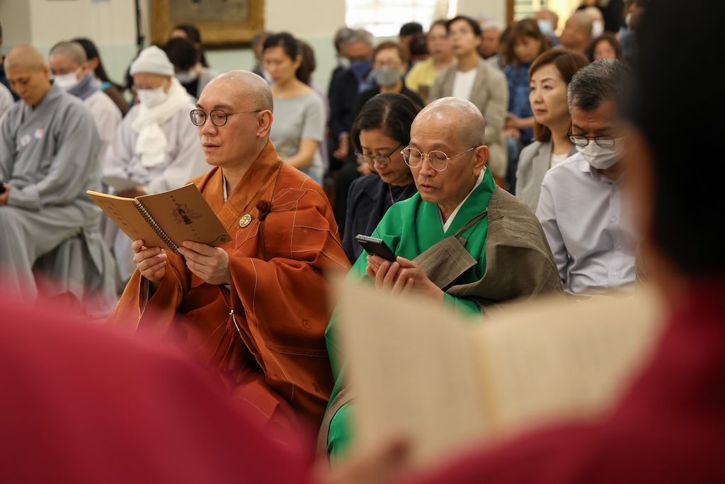 香港佛教真言宗居士林主席歐陽寶都先生捧著電子版誦本，與苑長僧徹法師專注地唱誦。
