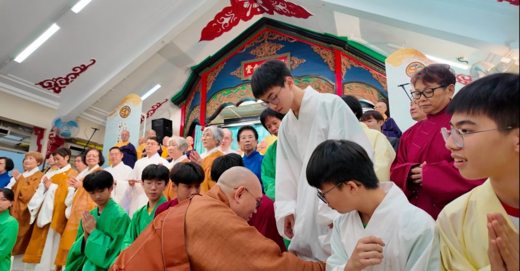 音聲佛事共賞會圓滿後,參與共賞會的寶覺小學學生一同合照,苑長為同學整理袍服。