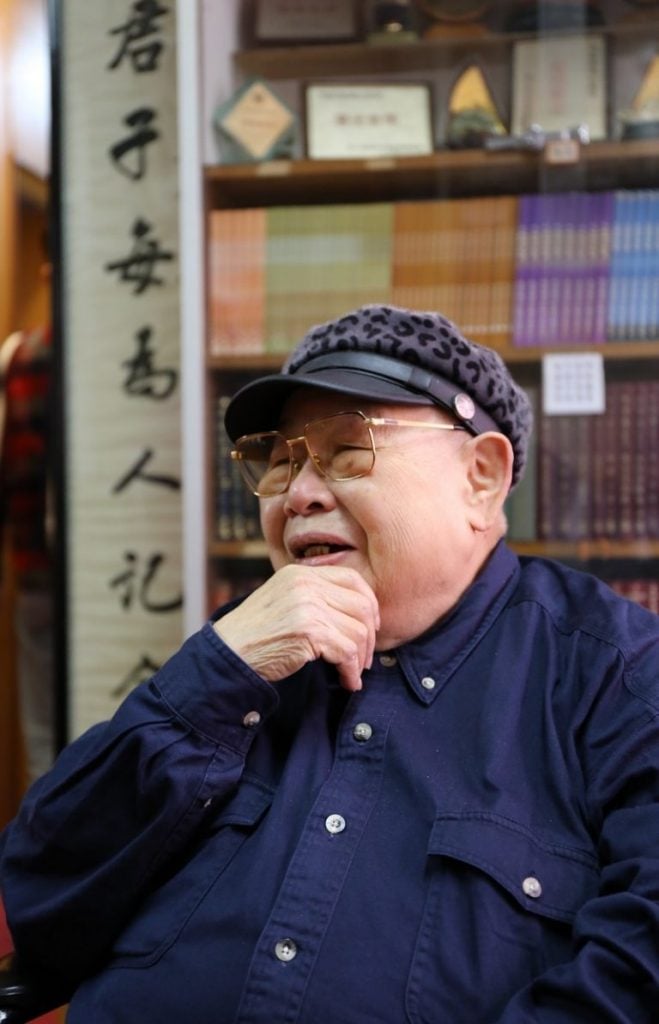 這2016年拍攝的照片，定格了容智寶居士（人稱「寶姊」，1931-2021年）端坐於明慧法師親筆書寫的那幅對聯前——「君子每為人記念，道風長與水流傳」。