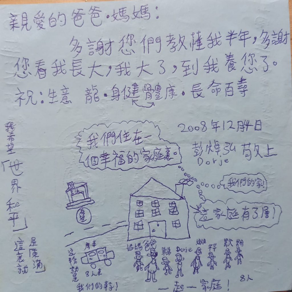 當時只有八歲的持明喇嘛，畫了一幅名為《我們住在一個幸福的家庭裏》的圖畫。畫面圖文並茂，細膩描繪了一家八口，其樂融融。