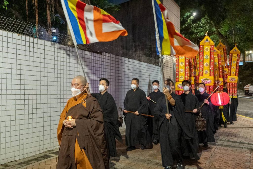 果毅法師帶領善信在寺外步行一圈，進行傳燈儀式。